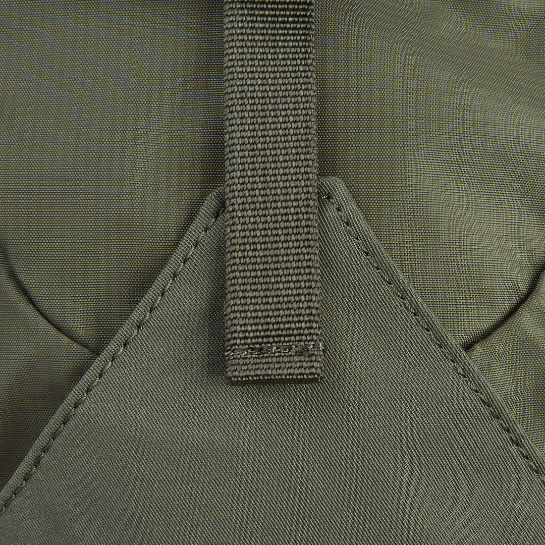 A close-up of the Vertx Long Walks Pack 15L shows a green fabric with Tactigami compatibility, brown strap, and textured pattern on the custom-fit body armor insert. The strap is stitched to a triangular section, with muted colors and durable materials ideal for use.