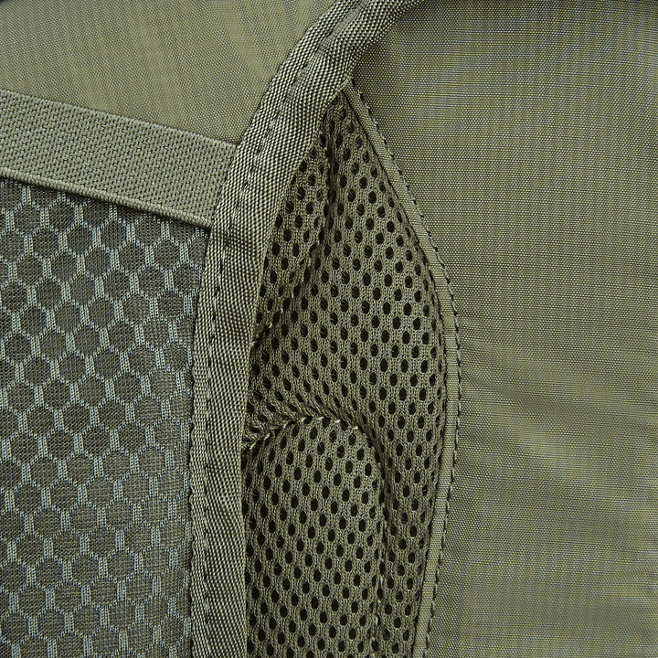 Close-up of the Vertx Long Walks Pack 28L, featuring a green backpack with a left mesh pocket and textured gray stripe. The fabric has honeycomb on one side and smooth on the other, perfect for adding body armor inserts for extra safety.