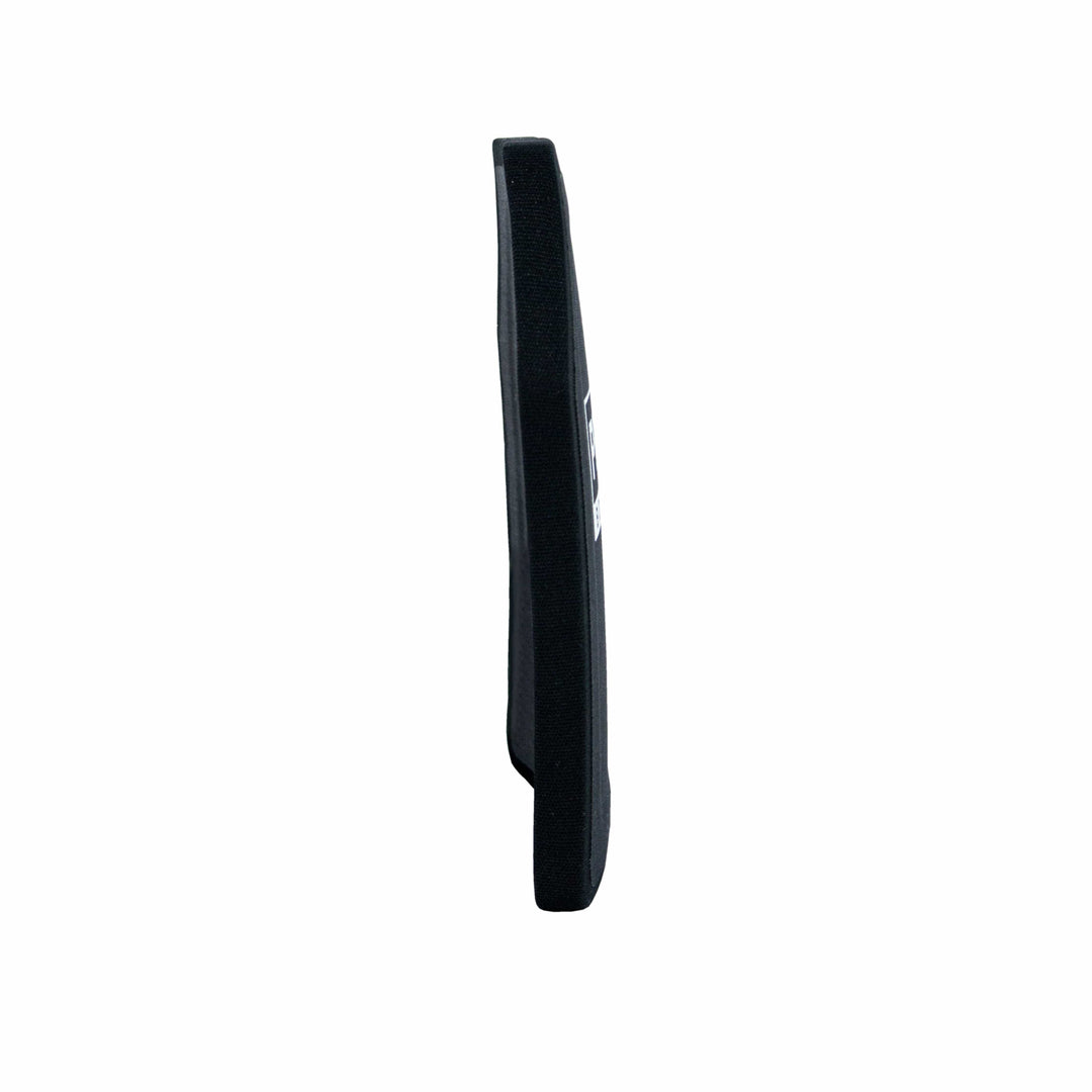 Side view of a black, rectangular protective vest panel, crafted from Ultra-High-Molecular-Weight Polyethylene. With its slim profile and Level III performance, this Premier Body Armor Nexus Level III ICW Plate is designed to integrate seamlessly into a vest for increased protection. A label with text is visible on the opposite side.