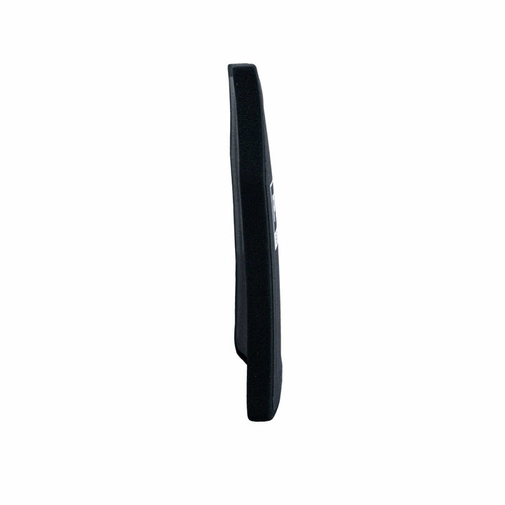 Side view of a black, rectangular protective vest panel, crafted from Ultra-High-Molecular-Weight Polyethylene. With its slim profile and Level III performance, this Premier Body Armor Nexus Level III ICW Plate is designed to integrate seamlessly into a vest for increased protection. A label with text is visible on the opposite side.