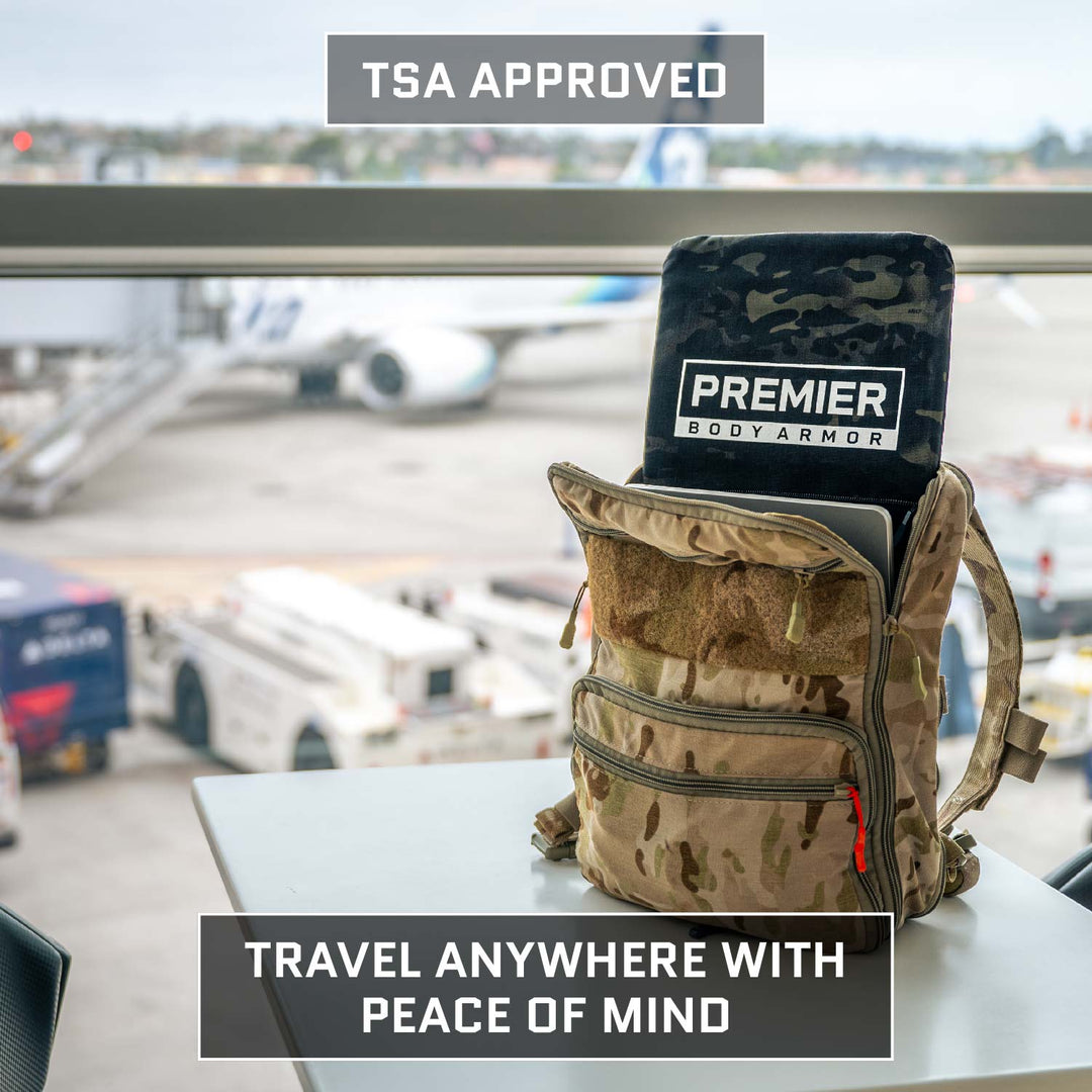 A Premier Body Armor Level IIIA Insert for 5.11 Rush 24/72 Pack is shown in a camo backpack with the black panel visible at an airport window. Outside are planes and vehicles. Text: "TSA Approved" and "Travel anywhere with peace of mind.