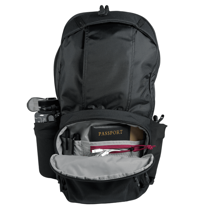 The Vertx Ready Pack X by Vertx is shown open, displaying an organized interior with a passport, camera on the side, pen, and small accessories in pockets. The main flap is unzipped for rapid access to your essentials.