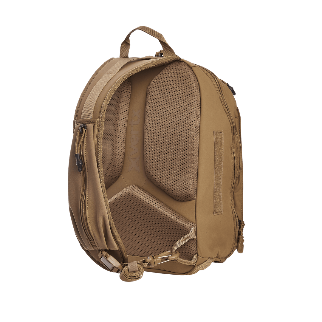 The brown backpack, similar to the Vertx Siege 15L Tactical Sling, offers ergonomic mesh padding and tactical features like a top handle, adjustable shoulder straps, side zippers, and a bottom buckle strap. The Vertx brand name is visible on the padding.