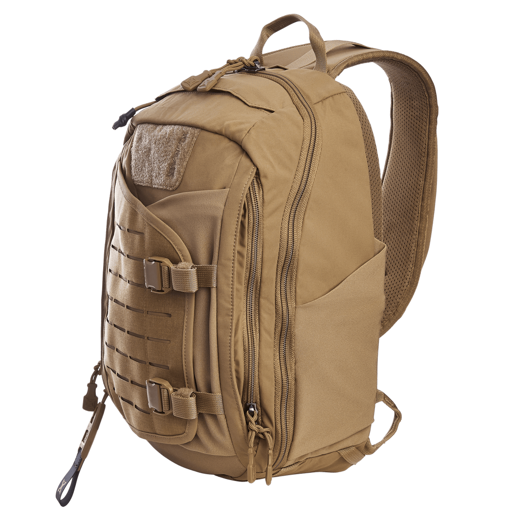 A tan Vertx Siege 15L Tactical Sling backpack, designed for readiness with zippered compartments, adjustable straps, side pockets, MOLLE panel, and buckle closures on the front. Displayed on a plain white background.