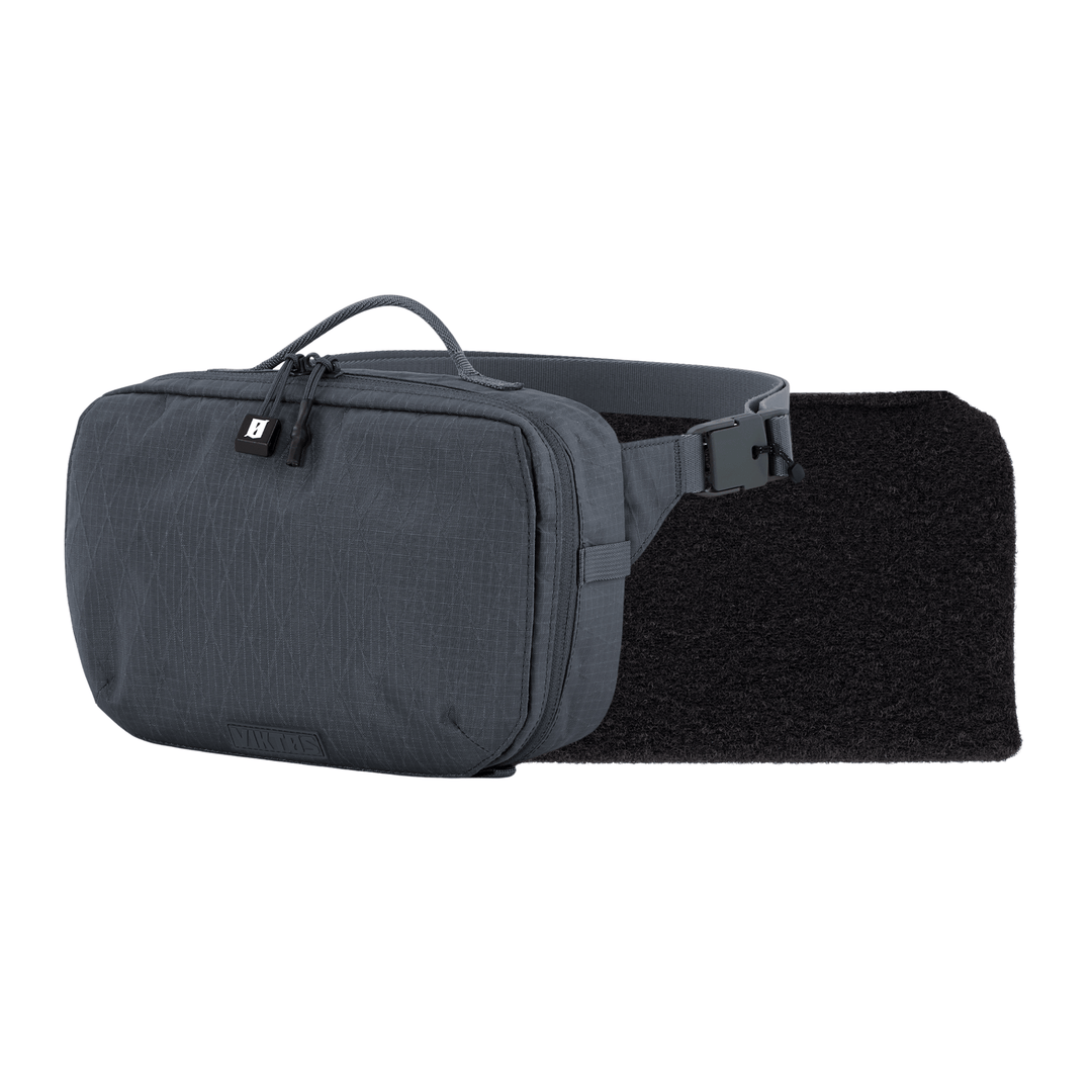 The Viktos/Premier Armored Viktos Upscale Hip Pack Bundle is a tactical rectangular-shaped hip pack with a zippered main compartment, a front strap with a plastic buckle, and a textured black back panel for added grip. It comes in gray.