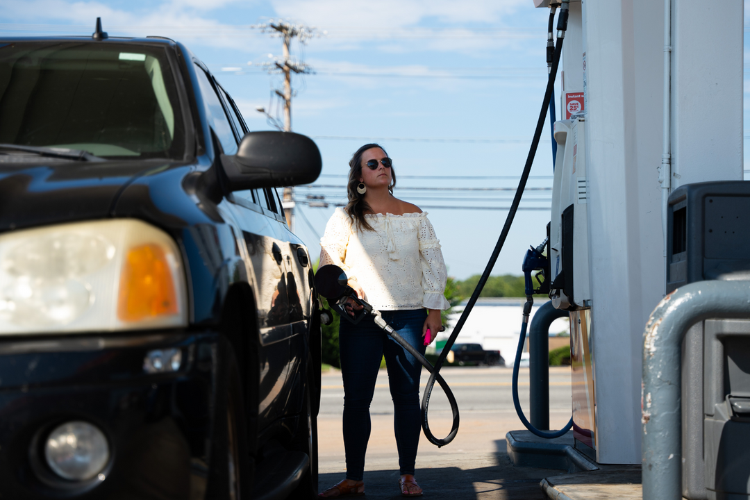 holding pepper spray at gas pump to stay safe