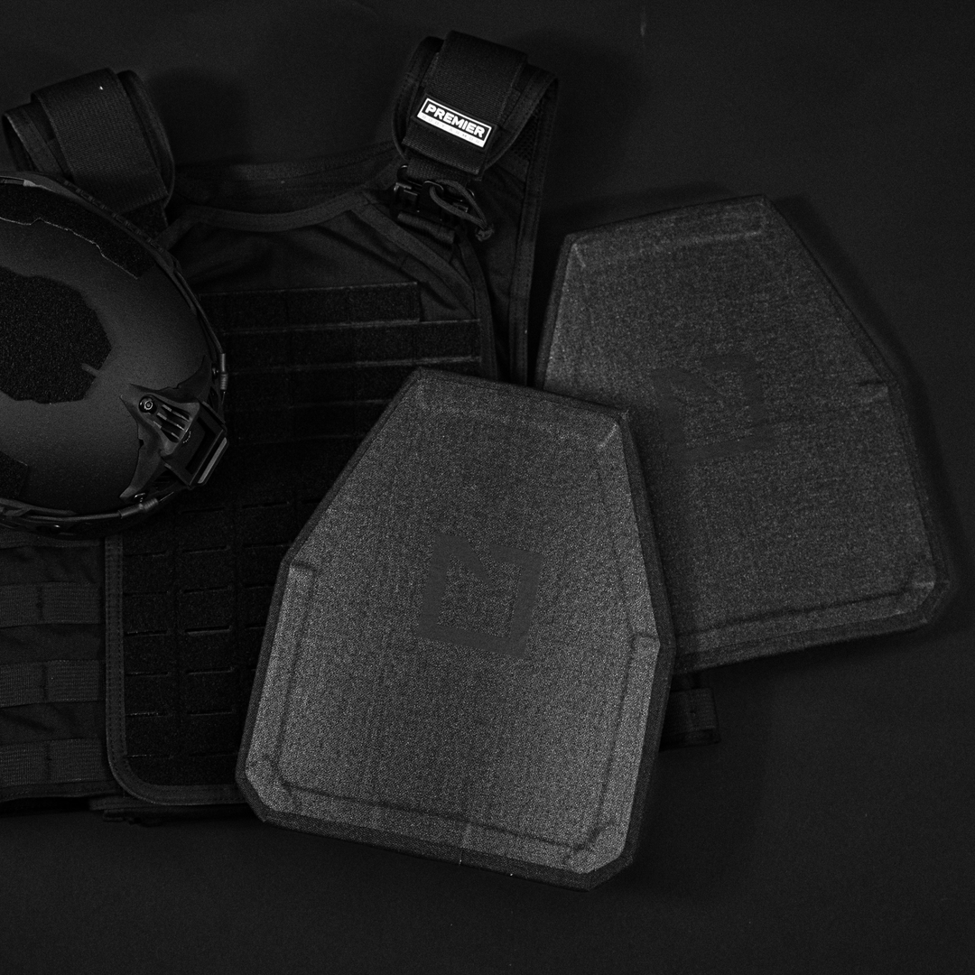 Black tactical vest with a helmet and two ballistic plates.