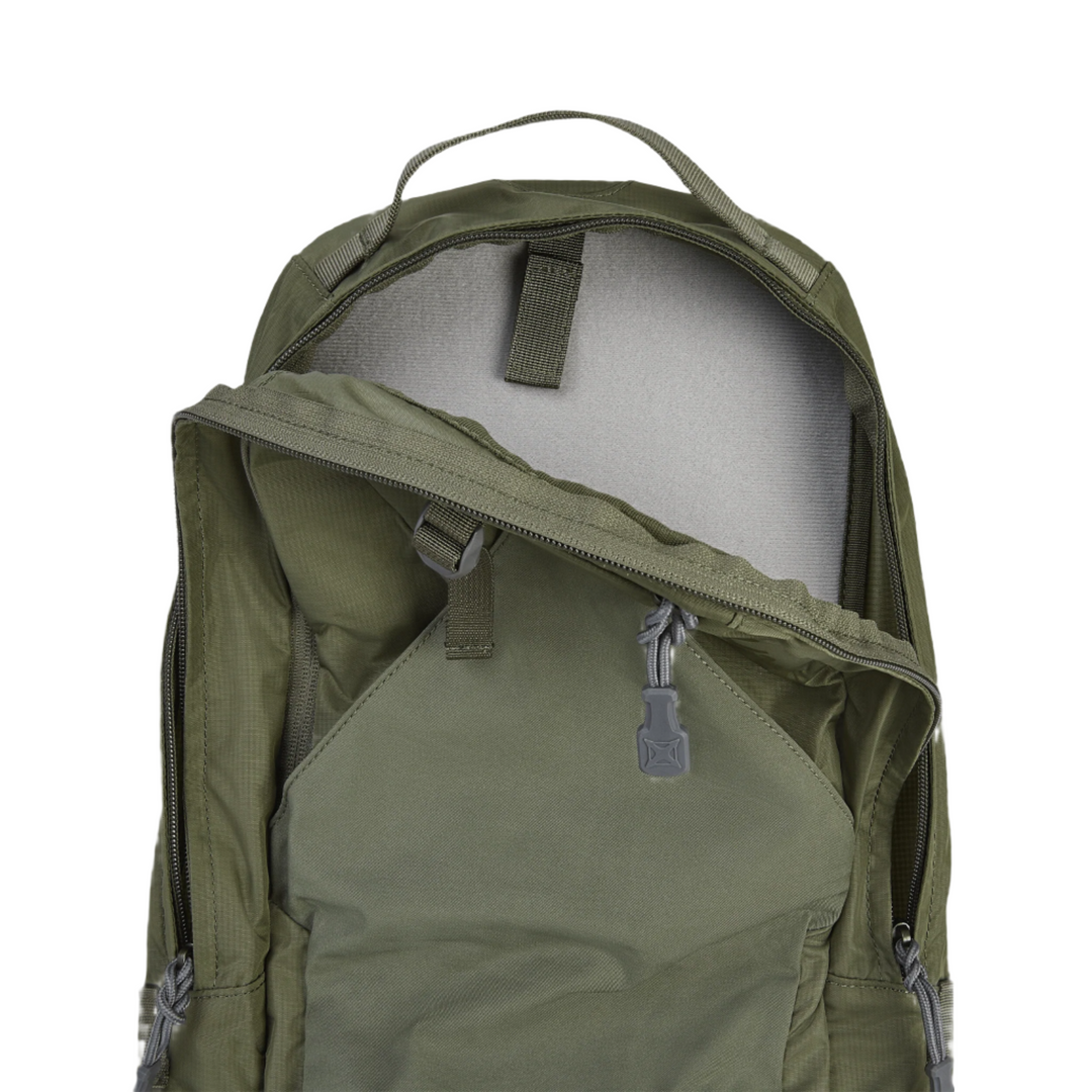 The Vertx Long Walks Pack 15L, an olive green backpack by Vertx, is displayed partially open to highlight its main compartment designed for Tactigami compatibility. The opened zippered top reveals a grey interior lining with a small strap affixed to the inside upper portion. While the upper zipper remains open, the side and bottom zippers are securely closed.