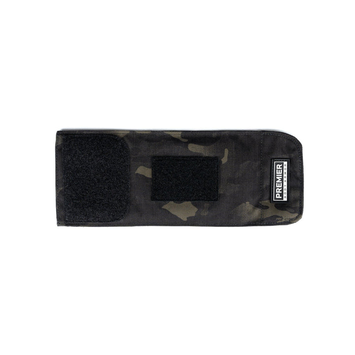 A rectangular, black camouflage-patterned Bulletproof Can Cooler with Velcro closures is shown. The cooler, designed with ballistic fibers, has two Velcro patches on the front and a label that reads "Premier Body Armor" on the lower right corner.