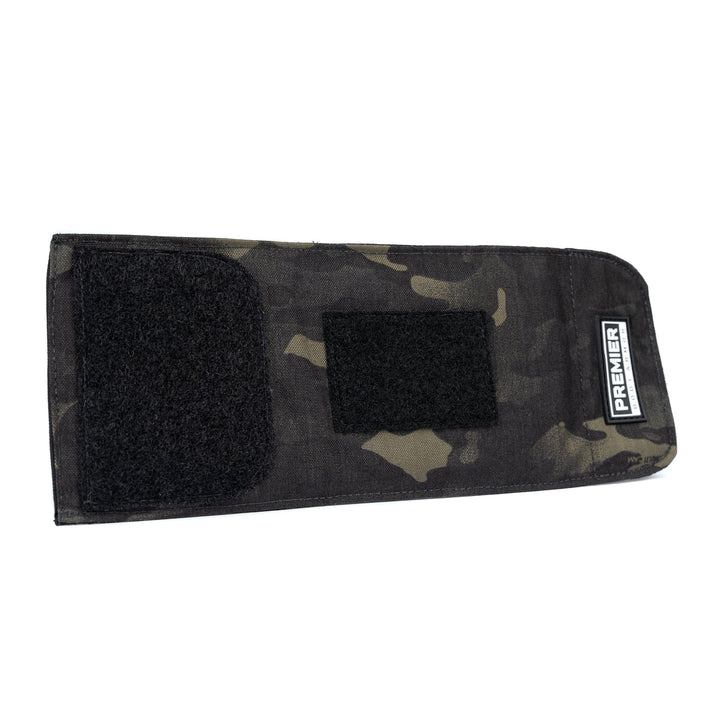 The Bulletproof Can Cooler by Premier Body Armor is a rectangular, camouflage-patterned fabric pouch featuring two black Velcro patches on the front. The word "PREMIER" is printed on a small white label on the right side. Crafted with ballistic fibers, this NIJ - Level II cooler includes a flap with Velcro fastener for secure closure.