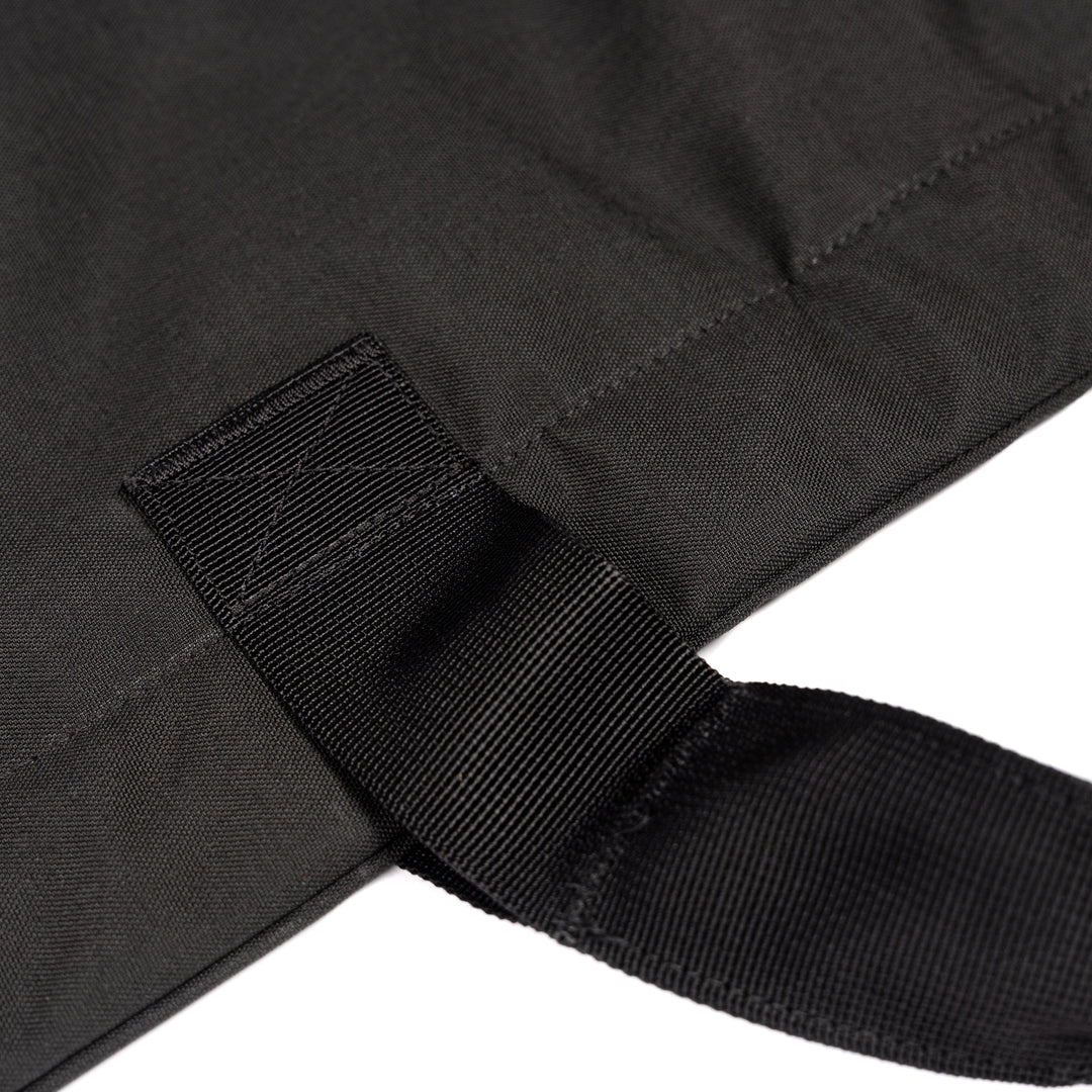 Close-up of black fabric with textured stitching and a looped strap. The durable Dyneema® material indicates it could be part of Premier Body Armor's Fortis Ballistic Blanket or another sturdy item.