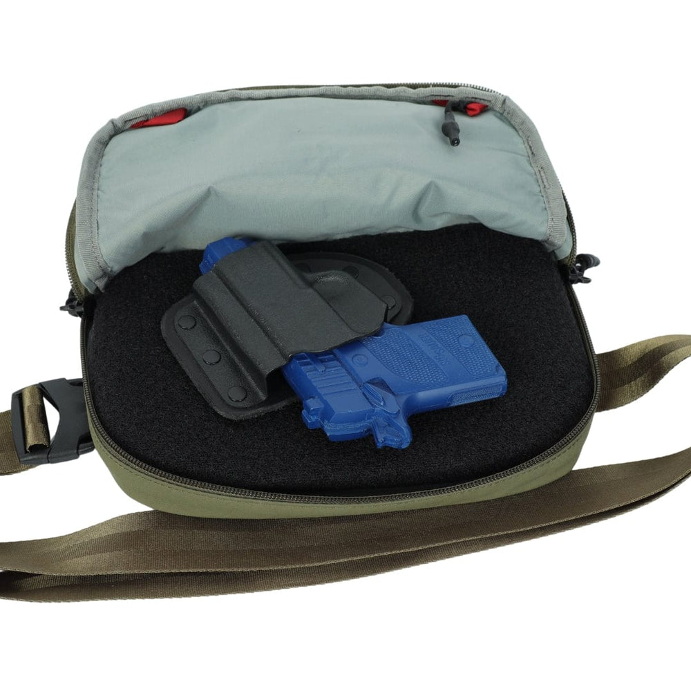 An open green and gray shoulder bag displays a foam insert with a blue training pistol in a black holster, compatible with the Premier Body Armor Vertx Everyday Fanny Pack+ Level IIIA Insert. The bag shows a visible zipper and brown strap.