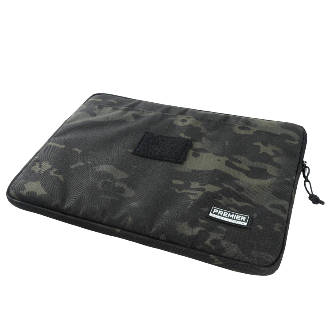 A black and gray camo-patterned Bulletproof Laptop Case by Premier Body Armor, featuring a zipper closure on the side and a small rectangular loop patch on the front. This TSA-approved sleeve has a label with the text "PREMIER.