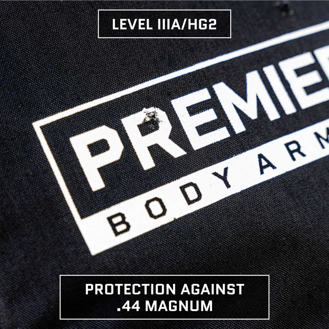 Close-up shot of black body armor fabric showing the "Premier Body Armor" logo. The Bulletproof Purse Insert Level IIIA features a para-aramid ballistic core, is labeled as providing Level IIIA/HG2 protection, and offers protection against .44 Magnum.