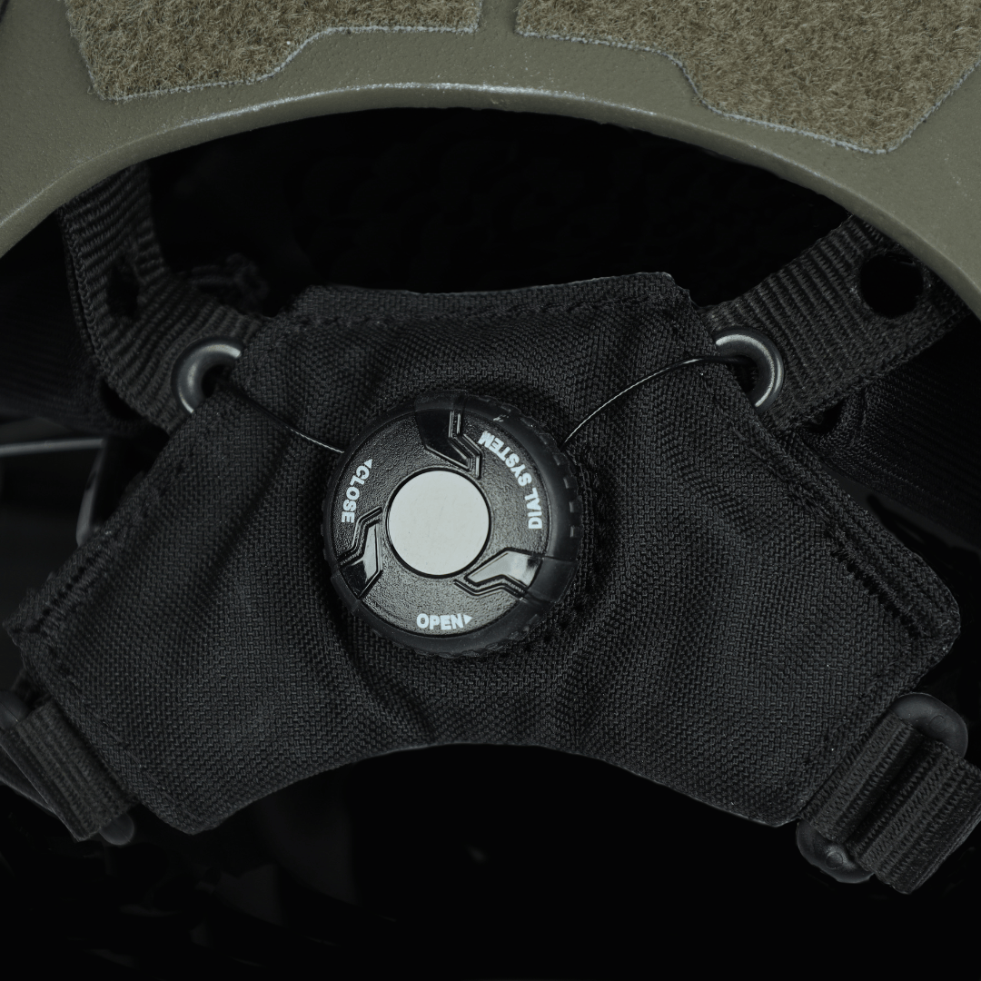 Close-up of the black adjustable dial retention system on a Fortis Bump Helmet by Premier Body Armor, with arrows indicating the open and close directions.