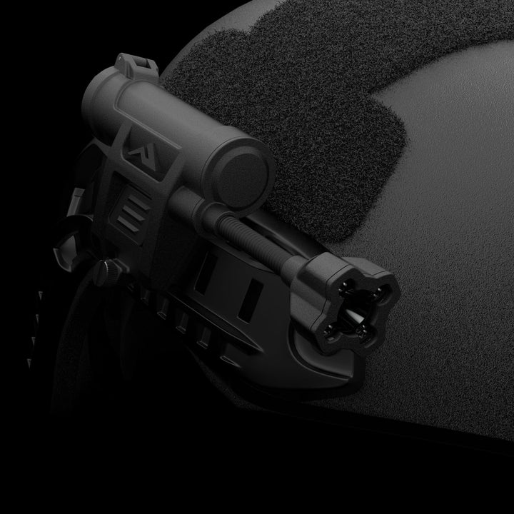 Close-up of a black tactical helmet with a Princeton Tec Charge X Helmet Light mounted on the side. The helmet features textured padding, and the cylindrical light includes attachments for tactical illumination. The background is solid black.