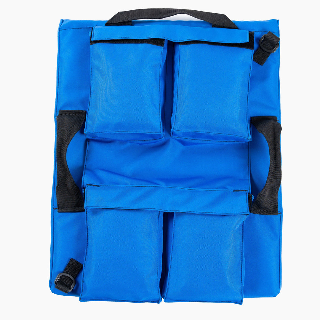 The First Aid Shield by Premier Body Armor is a blue fabric backpack featuring four rectangular pouches—two at the top and two at the bottom. It has black handles and straps, along with black buckles on the sides. The pouches and straps are securely stitched to the main body, making it an ideal Level III+ School Shield for school safety.