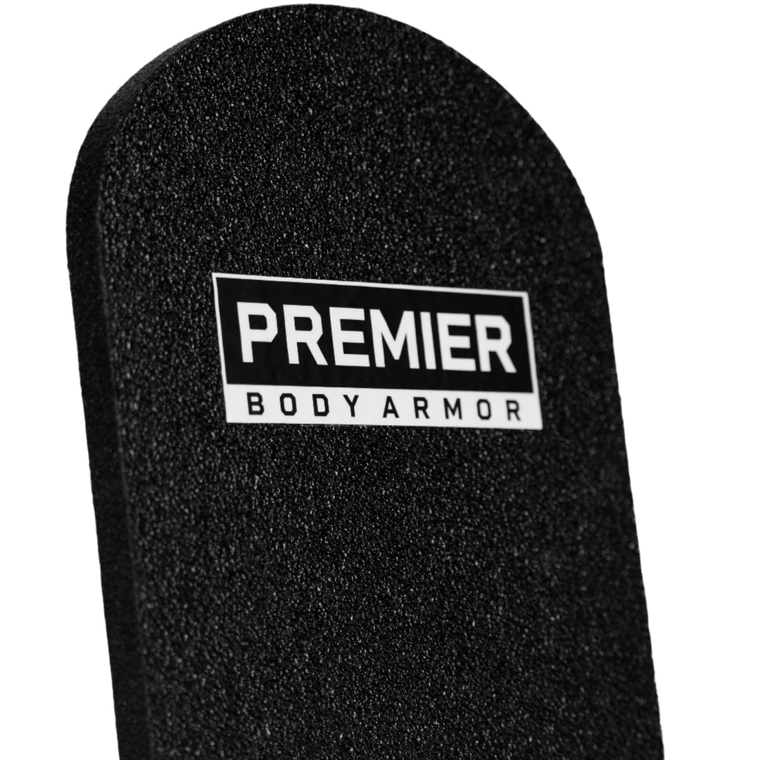 Close-up of a black Universal Fit Level III+ Rifle-Rated Backpack Insert against a white background. A rectangular label near the top reads "Premier Body Armor" in white text on a black background. The discreet protection plate, suitable as a Level III+ Backpack Insert, has a textured surface and rounded top corners.