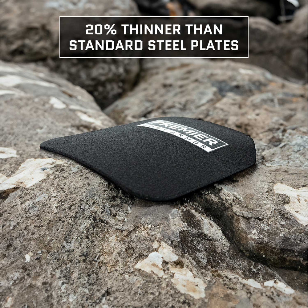 A black Durus 650 Level III+ Plate from Premier Body Armor is placed on a rocky surface, providing ballistic protection. Above it, the text declares "20% Thinner Than Standard Steel Plates," highlighting its multi-curve design for improved comfort and defense.