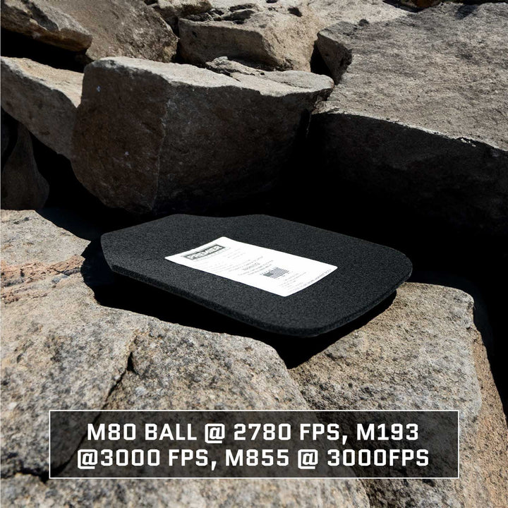 A black Durus 650 Level III+ Plate by Premier Body Armor rests on rocky terrain, providing ballistic protection. The plate features a label with partially obscured text, and overlayed information highlights M80 Ball @ 2780 FPS, M193 @ 3000 FPS, and M855 @ 3000 FPS.