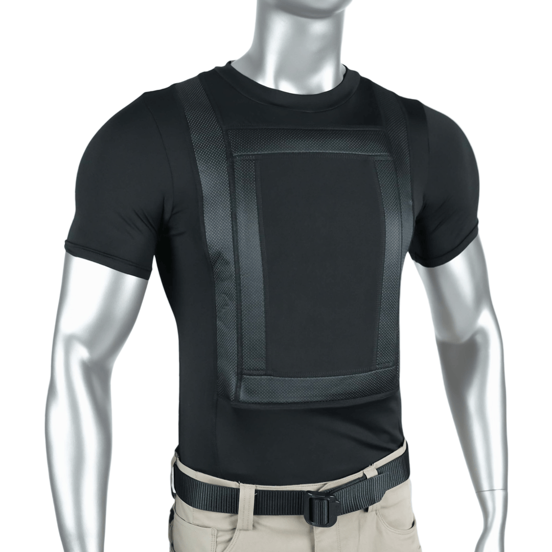 A silver mannequin wears the Premier Body Armor Everyday Armor T-shirt 360 Core, a fitted black tee with a textured chest panel and straps for concealed armor, paired with beige pants and a black belt.