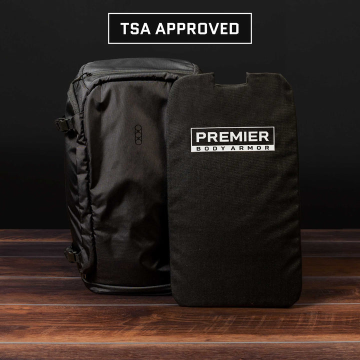 On a wooden surface against a dark background, there's an Eberlestock Fade Adapt Level IIIA Insert from Premier Body Armor. Its sleek design and premium features are prominently displayed.