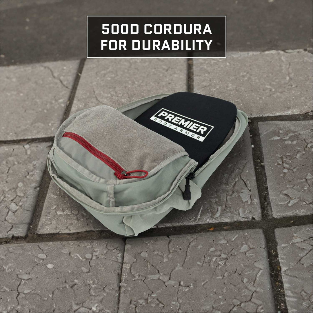 A light gray backpack featuring a red zipper is placed on a tiled surface. Inside, a tag indicates it’s an EDC solution by Vertx/Premier. The image showcases the "500D Cordura for durability," emphasizing the Armored Vertx Ghost Pack Bundle with Level IIIA ballistic protection.