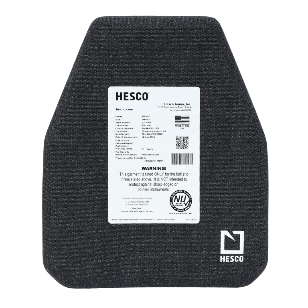 A Hesco 4403MC Level IV Plate ballistic armor plate features a visible product label with specs, warnings, and certification info on a white background. The lightweight dark gray ceramic plate has angled corners.