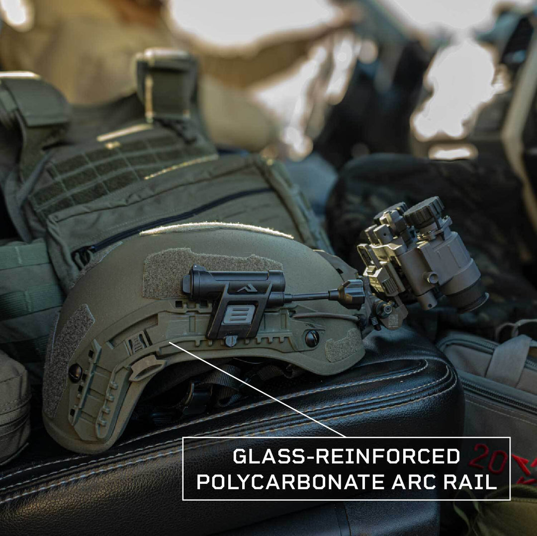 The Fortis Ballistic Helmet by Premier Body Armor, featuring advanced protective technology, a glass-reinforced polycarbonate ARC rail with a label, and a mounted night vision device, is placed on a car seat, with tactical gear details visible in the background.