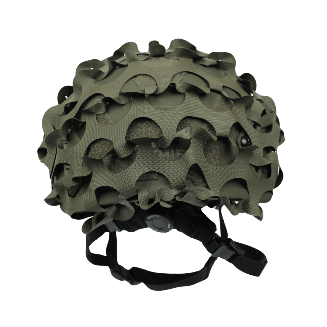The OPE Gear Helmet Scrim - Camo Helmet Cover by OPE Gear features irregular, wavy cutouts and fits over military helmets with a matte green finish, offering compatibility with ACH helmet accessories and adjustable black chinstraps.