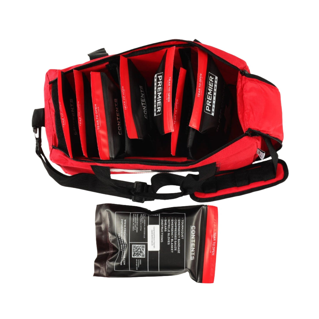 An Active Response Bleed Control Kit by STAT, featuring a red medical kit bag, is open and showcasing its neatly organized compartments with labeled medical supplies essential for emergency situations. One package labeled "Sodium Chloride" is placed outside the bag. The kit has a black strap and is designed for easy access to its contents.