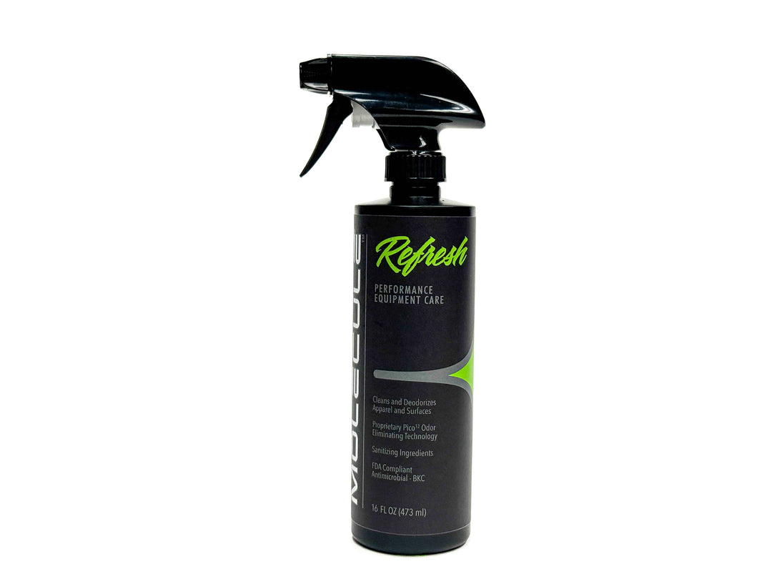 A 16 oz (473 mL) black spray bottle of Molecule Refresh Sprayer, featuring green and white text on the label, is upright against a white background. Designed for cleaning and deodorizing equipment and surfaces, this product serves as an effective gear odor eliminator and deodorizer for technical fabrics.