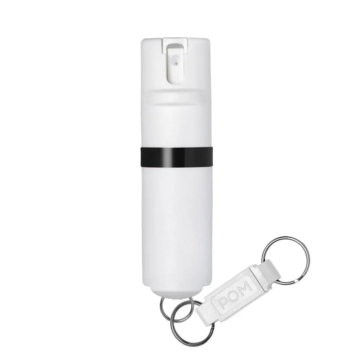 The POM Keychain Pepper Spray by POM is a white canister with a black band, featuring a quick-release keychain and "POM" tag for easy access and portability.