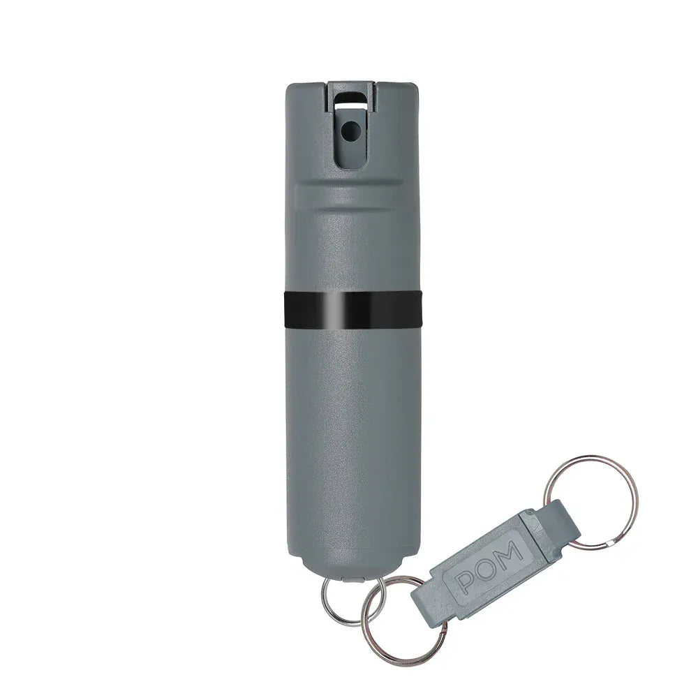 The POM Keychain Pepper Spray by POM is a compact, cylindrical gray canister with a black band and quick-release keychain attachment—ideal for portable self-defense.