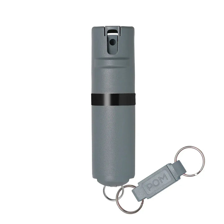 The POM Keychain Pepper Spray by POM is a compact, cylindrical gray canister with a black band and quick-release keychain attachment—ideal for portable self-defense.