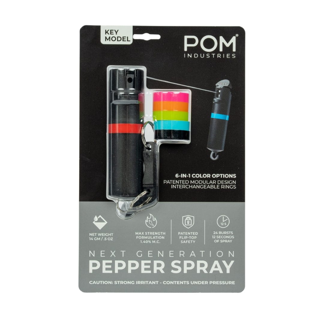 The POM Keychain Pepper Spray by POM features a black canister, four colored interchangeable rings, patented safety, modular design, compact self-defense use, and a 14g net weight.