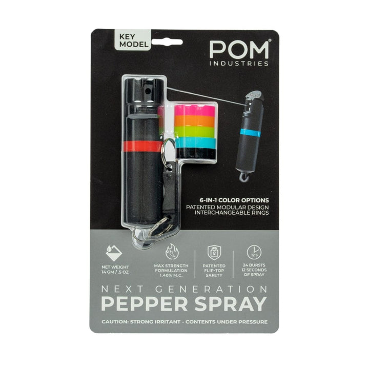 The POM Keychain Pepper Spray by POM features a black canister, four colored interchangeable rings, patented safety, modular design, compact self-defense use, and a 14g net weight.