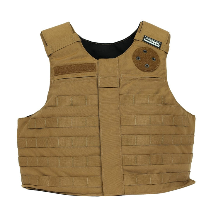 The Patrol Foxtrot by Premier Body Armor is a tan carrier vest featuring multiple horizontal webbing straps, Velcro patches, padded shoulder straps, plate pockets, and a small black "PREMIER" label near the collar.