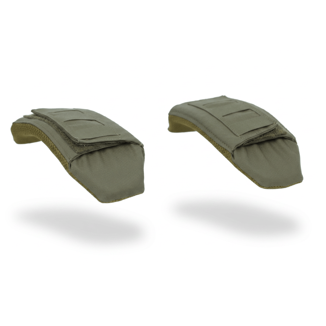 Displayed on a white background are two khaki-colored Fortis Shoulder Pads by Premier Body Armor, each made of padded fabric and equipped with hook and loop fasteners. The pads appear to be floating, casting soft shadows beneath them. Military, law enforcement, and first responder discounts are available for eligible buyers.