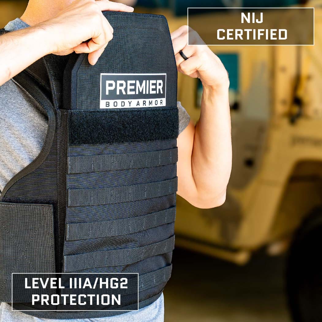 A person is shown putting on a black body armor vest labeled "Premier Body Armor." The vest, which is part of the Overt/Covert Vest Bundle (old), is depicted as NIJ Certified with Level IIIA/HG2 protection. In the background, there is a blurred vehicle that appears to be military or utility.