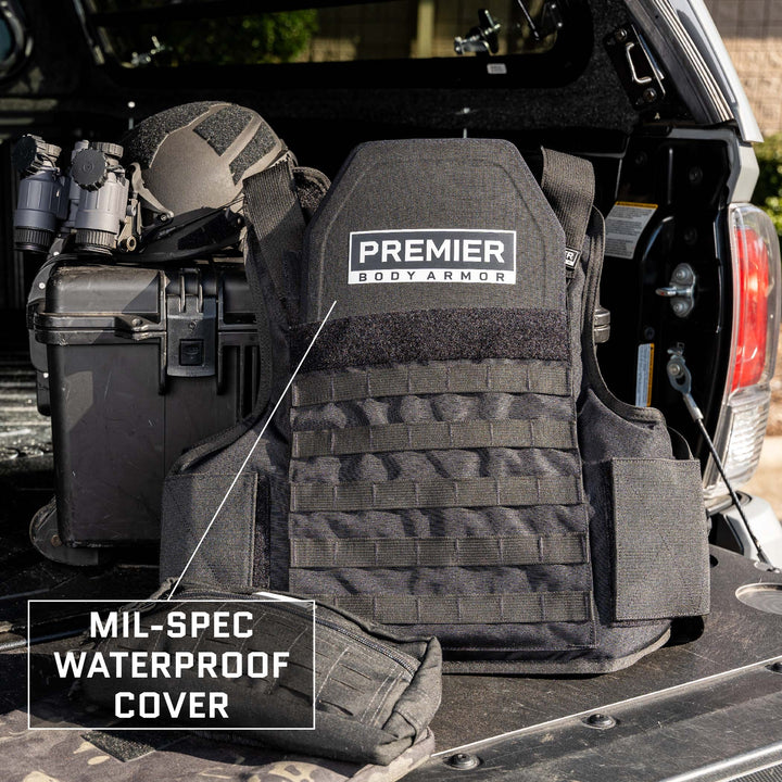 The Premier Body Armor Adaptable Response Loadout with Level IIIA ballistic panels is displayed on the tailgate of a vehicle. Equipped with a mil-spec waterproof cover, helmet, and black case with binoculars, the outdoor scene suggests a tactical or military setting.