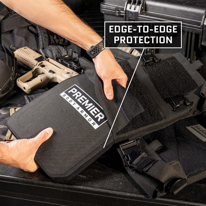 A person is holding a piece of body armor labeled "Fortis III+ GT/RF2 Single-Curve" by Premier Body Armor. The scene includes tactical gear such as a firearm and straps. A graphic overlay reads "Edge-to-Edge Protection," showcasing the Level III+ ballistic plate reinforced with Boron Carbide tiles for superior defense.