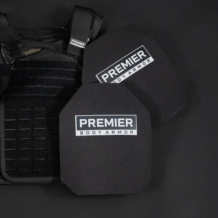 A dark background showcases black tactical gear, including a helmet and a vest with multiple compartments. The prominently labeled "Premier Body Armor" features STRATIS-Max Level IV Plates for superior ballistic protection with an advanced multi-curve design.