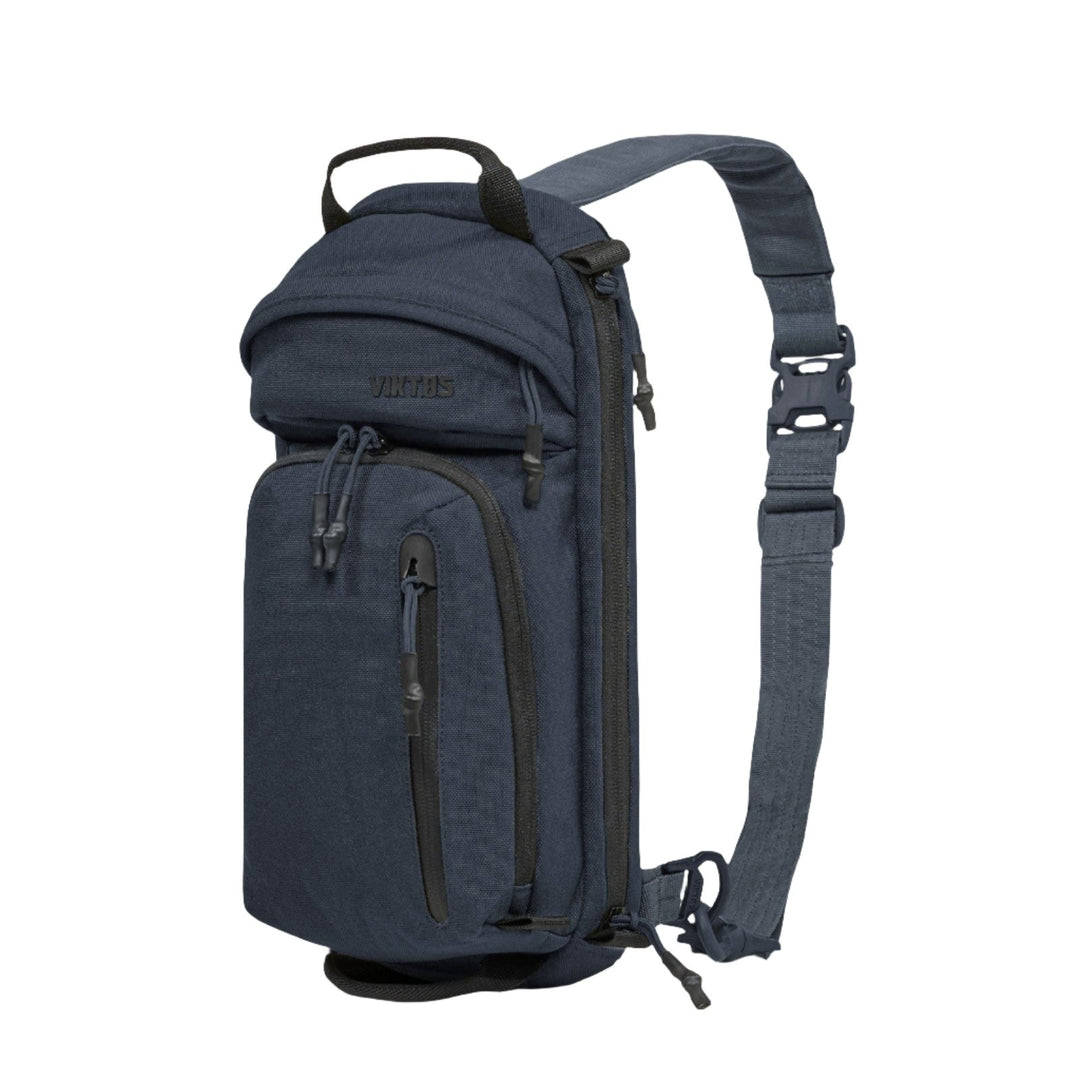 The image shows the Viktos Upscale3 Sling, an upscale dark blue sling backpack designed for concealed carry, with multiple zippered compartments. This Viktos branded backpack features a padded shoulder strap with a buckle, pull tabs for easy access, and durable fabric.