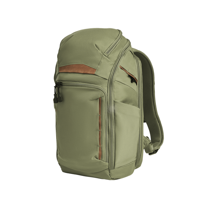The Vertx Gamut 22L Pack in Evergreen features a zippered top compartment, front zipper pocket, brown accent strip, two side pockets, rapid access CCW compartment, and adjustable shoulder straps, shown on a white background.