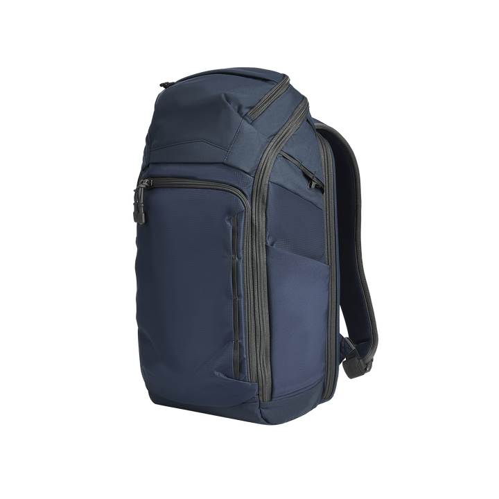 The Vertx Gamut 26L Pack by Vertx is a dark blue EDC backpack with multiple zippered compartments, a rapid access CCW compartment, and black padded shoulder straps, shown against a plain white background.
