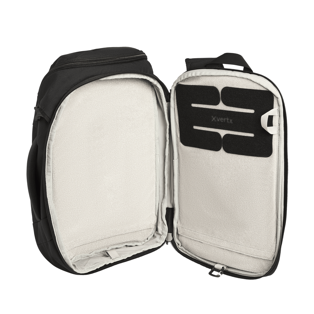The Vertx Gamut 18L Sling by Vertx is shown open, featuring a spacious, light-colored interior with a rectangular padded section labeled "Vertx" and a dedicated CCW compartment for rapid access inside the top flap.