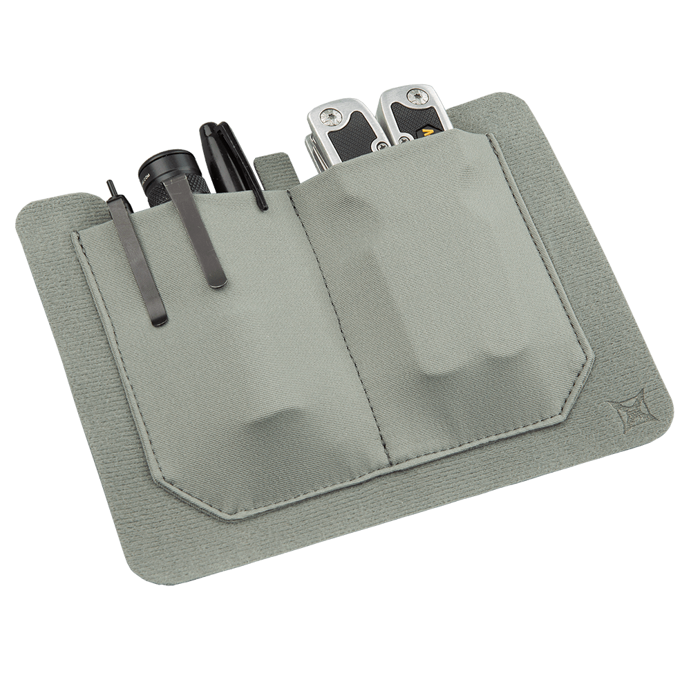 The Vertx Stretch Pocket Large by Vertx is a gray fabric EDC (Everyday Carry) organizer with two pockets, designed to hold a pen, flashlight, and multi-tool. Its minimalist design features stitched edges and the Kit Organization Tactigami system, making it perfect for keeping small tools and accessories organized and easily accessible.