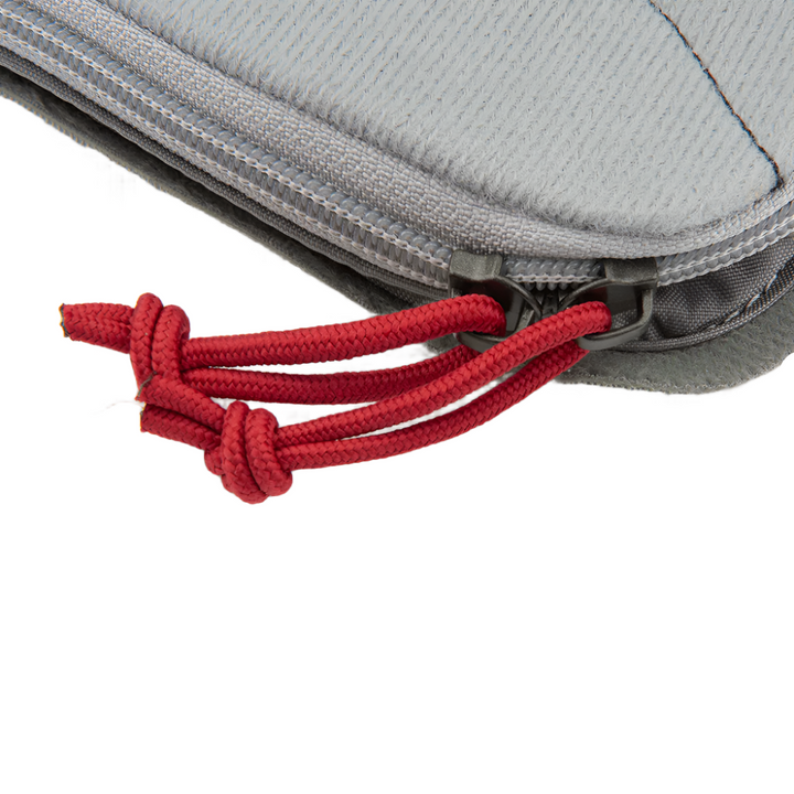 Close-up of a gray zippered Vertx Pack Organizer Medium fabric case with a red knotted cord attached to the zipper pull. The Vertx case features a textured surface and appears to be partially open. The background is plain white.