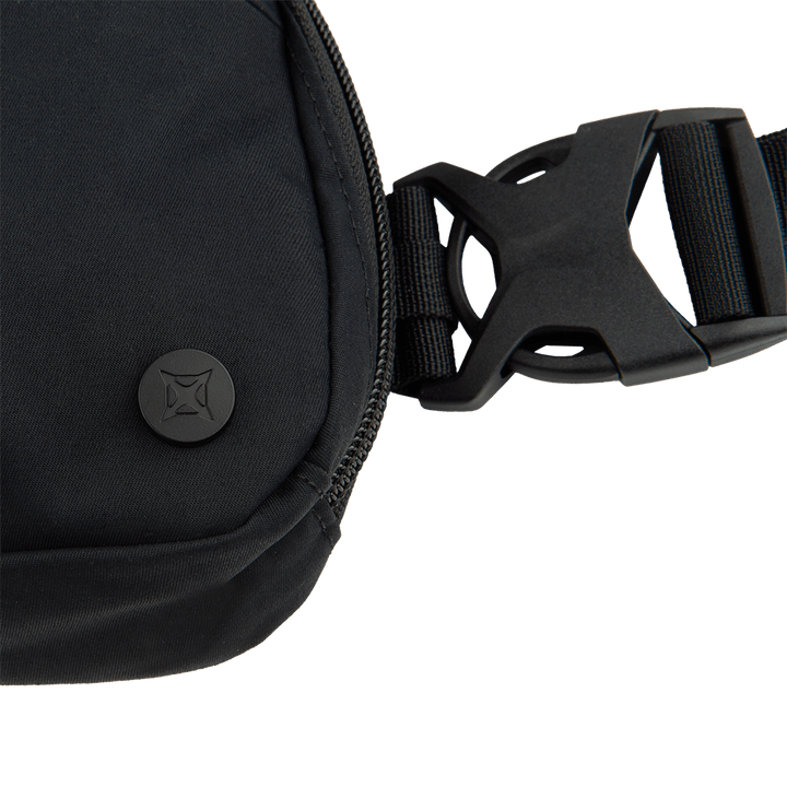 Close-up of the Vertx Everyday Fanny Pack 2.0 in black, featuring a concealed carry design, zipper closure, logo-embossed round button, and an adjustable strap with a large plastic buckle.